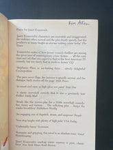 Load image into Gallery viewer, Lean Mean Thirteen by Janet Evanovich: photo of the first page which shows the name of a previous owner written in blue pen, at the top of the page.