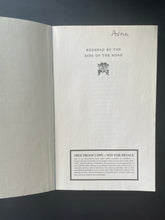 Load image into Gallery viewer, Redhead By the Side of the Road by Anne Tyler: phot of the second page which has the name of a previous owner written at the top of the page in black pen.