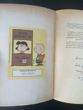 Load image into Gallery viewer, The Chandler Collection-Volume One by Raymond Chandler: photo of the inside of the front cover which has discoloured slightly along the edges, and has a large Peanuts cartoon sticker on it with the name of a previous owner.