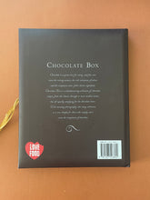 Load image into Gallery viewer, The Chocolate Box by Fiona Roberts: photo of the back cover which shows very minor (barely noticeable) scuff marks along the edges, and minor scratching.