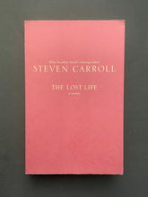Load image into Gallery viewer, The Lost Life by Steven Carroll: photo of the front cover which shows long creases running down the length over of the cover, and minor creasing on the top-right corner.