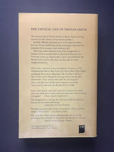 Load image into Gallery viewer, The back cover of the book 'The Unusual Life of Tristan Smith' by Peter Carey. The photo shows minor scuff marks along the edges, and a large crease on the bottom-left corner.