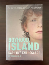 Load image into Gallery viewer, Boyhood Island by Karl Ove Knausgaard book: photo of the front cover. There are very minor scuff marks visible on the top-right and bottom-right corners, and along the bottom edge of the cover.