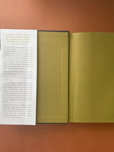 Load image into Gallery viewer, Searching for Schindler by Tom Keneally: photo of the inside of front cover and the first page, which shows a crease running down the flap of the dust jacket, and a faint vertical bend/crease running down the length of the first page. No other creased pages in the book.