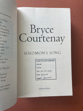 Load image into Gallery viewer, Solomon's Song by Bryce Courtenay: photo of the title page which has a black, square shaped stamp on the bottom-half of the page.