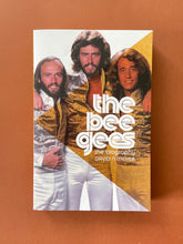 Load image into Gallery viewer, The Bee Gees-The Biography by David Meyer: photo of the front cover which shows a very faint and shallow X-shaped indentation on the top-right corner.