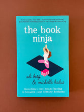 Load image into Gallery viewer, The Book Ninja by Ali Berg & Michelle Kalus: photo of the front cover which shows very minor (barely visible) scuff marks along the edges.