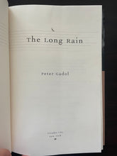 Load image into Gallery viewer, The Long Rain by Peter Gadol book: photo of the minor crease running down the middle of the title page.