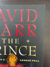 Load image into Gallery viewer, The Prince by David Marr book: photo of very minor scuff mark on the top-right corner of the front cover. Also visible is a small scratch between the red letters D and R.