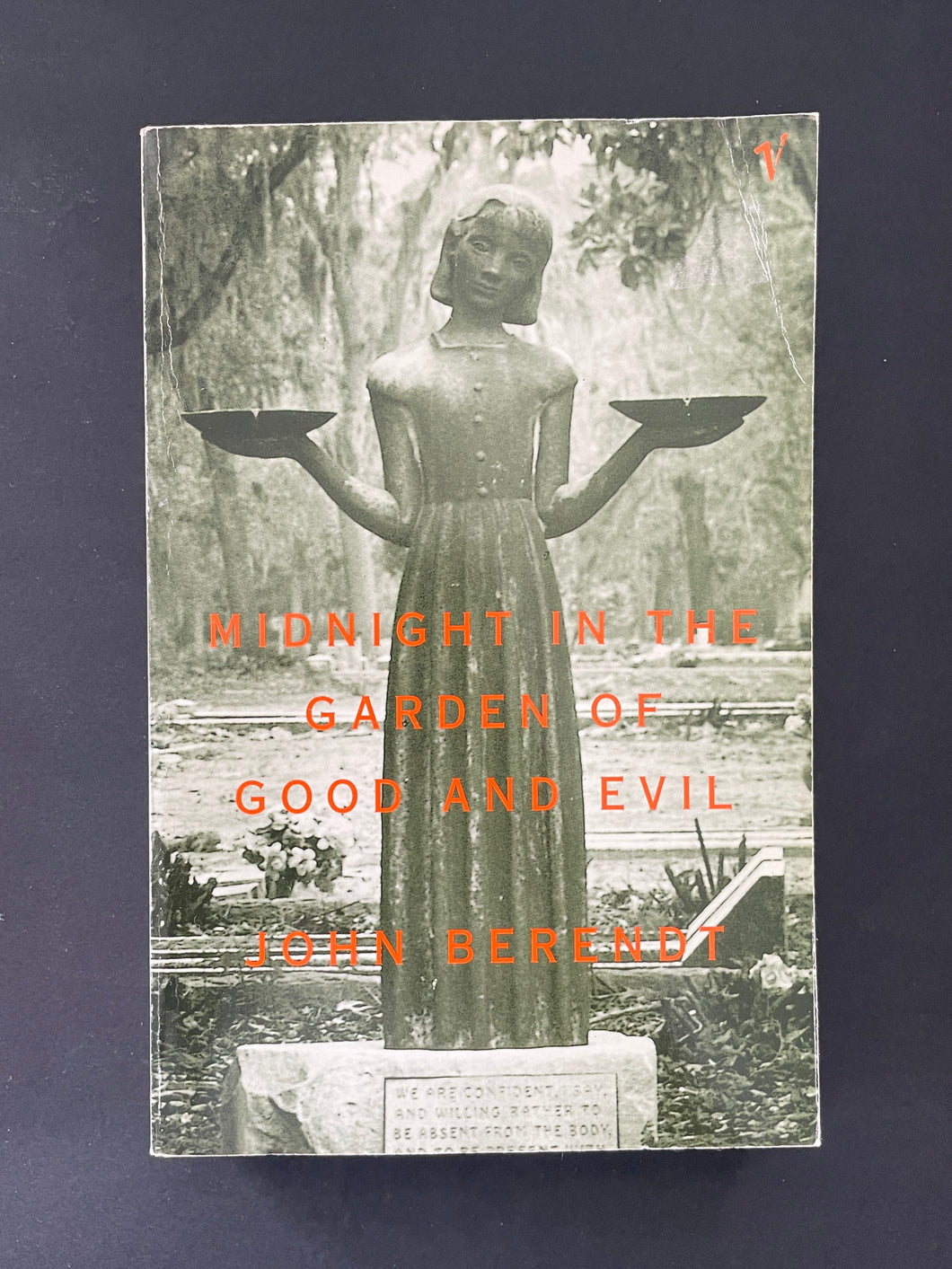 Midnight in the Garden of Good and Evil by John Berendt: photo of the front cover which shows creasing on the top-right and top-left corners, and very minor scuff marks.