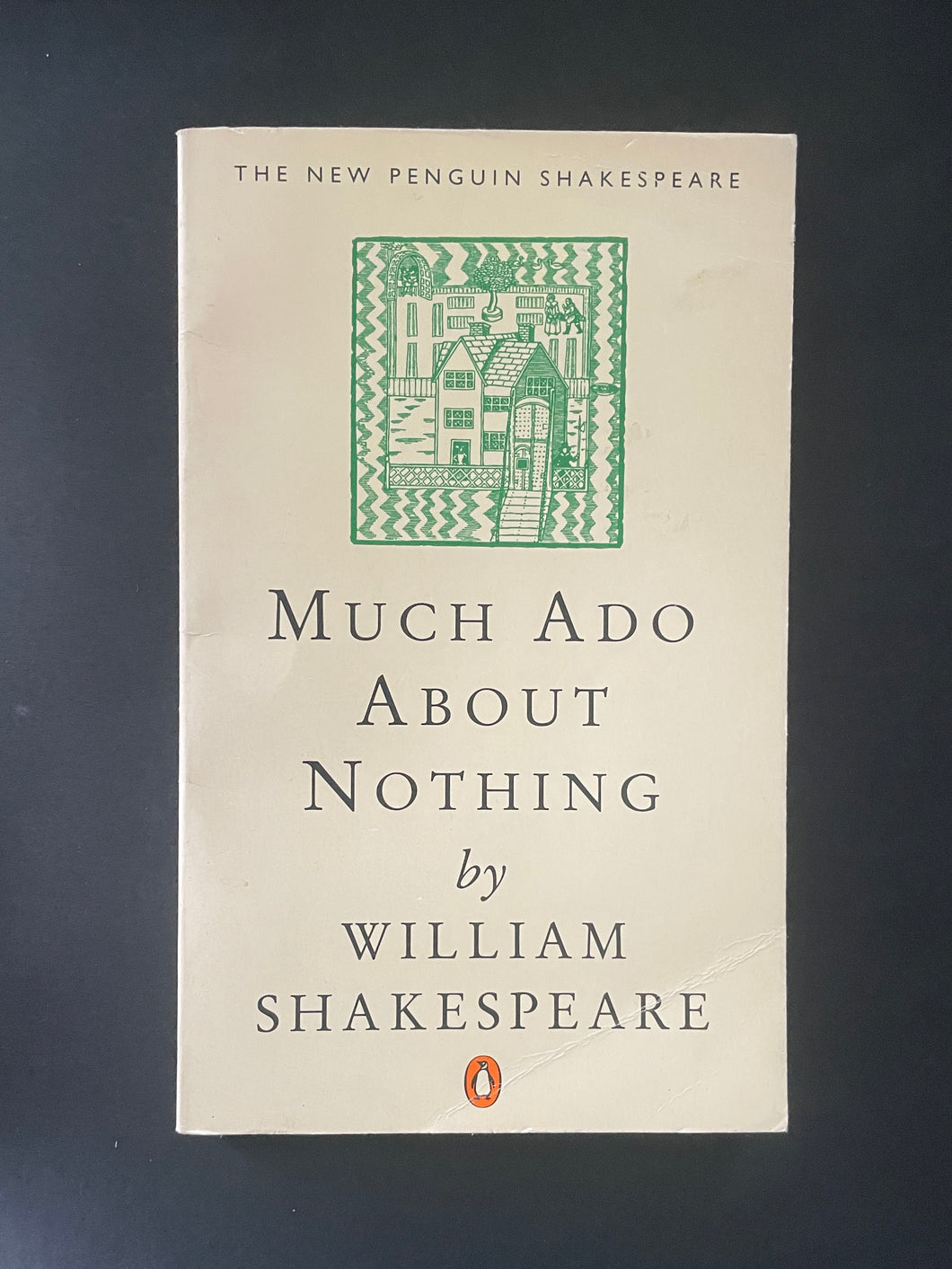 Book cover of 'Much Ado About Nothing' by William Shakespeare with a green decorative design on a dark background. Some creasing on the top-right corner, and an obvious crease on the bottom-right corner.