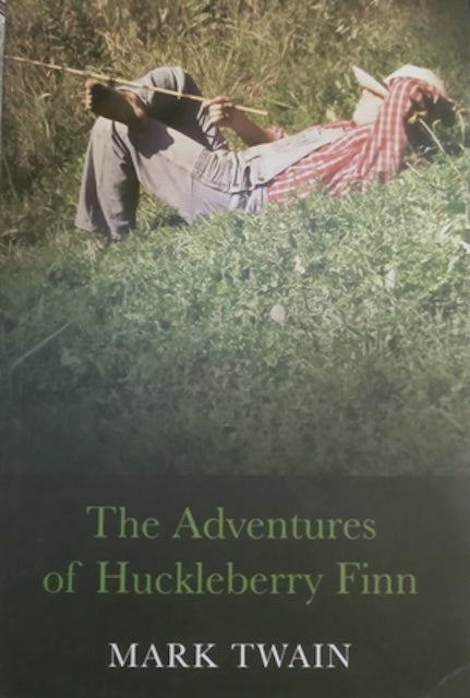 Book cover of 'The Adventures of Huckleberry Finn' by Mark Twain with a person lying in grass.
