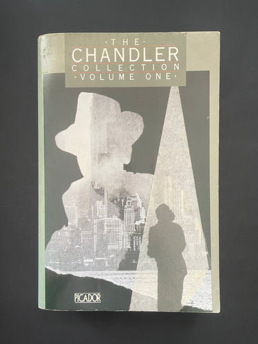 Book cover of 'The Chandler Collection Volume One' by Raymond Chandler with a silhouette design on a dark background. The photo shows minor scuff marks and scratching, and a minor crease on the bottom-right corner.