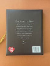 Load image into Gallery viewer, The Chocolate Box by Fiona Roberts: photo of the back cover which shows very minor (barely noticeable) scuff marks along the edges, and minor scratching.
