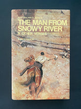 Load image into Gallery viewer, Book cover of &#39;The Man from Snowy River &amp; Other Verses&#39; by A. B. Paterson with a horse and rider illustration on a dark background. The photo shows minor scuff marks along the edges of the dust jacket.
