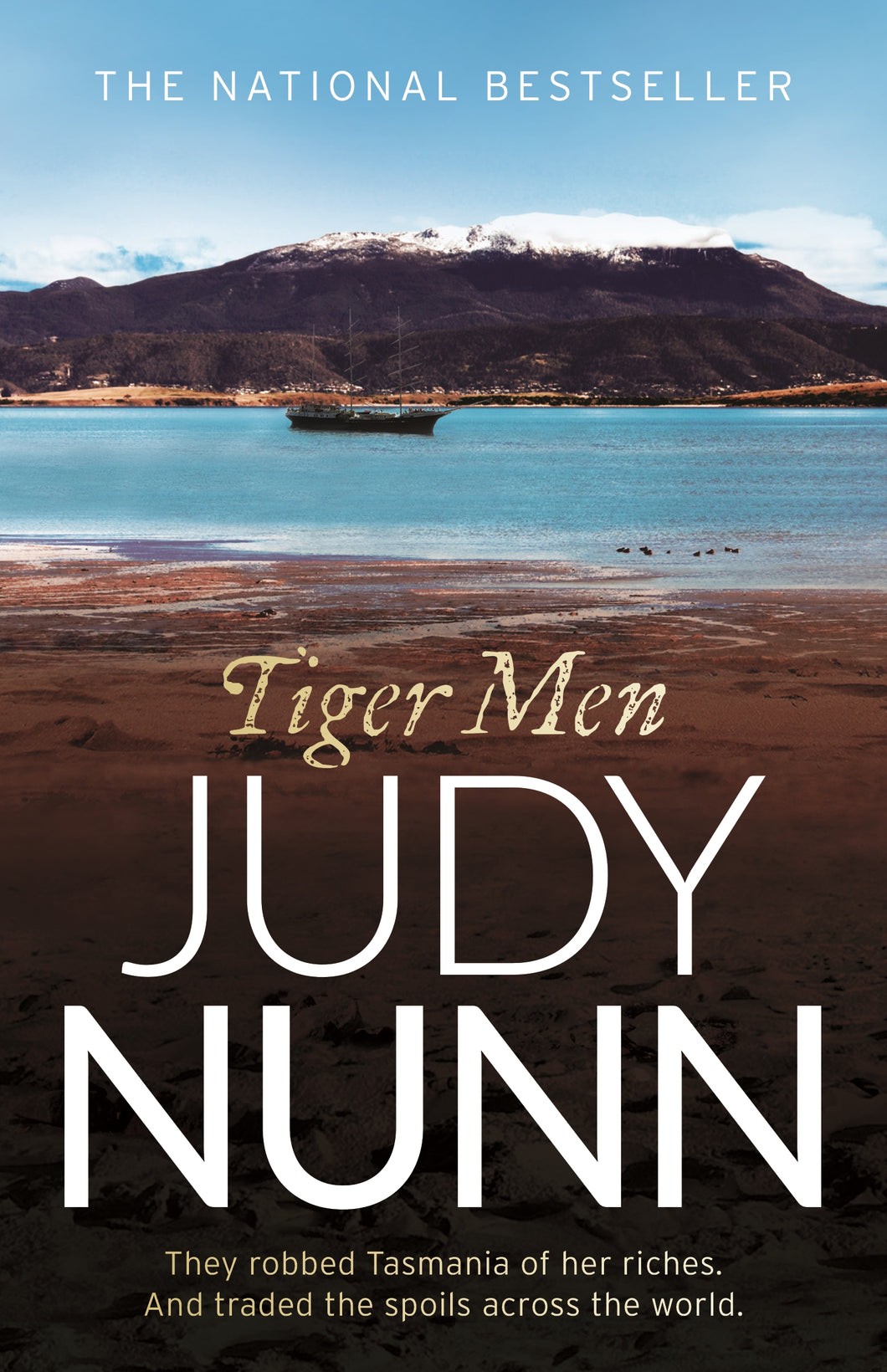 Book cover of 'Tiger Men' by Judy Nunn with a scenic background of a lake and mountains.