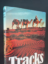 Load image into Gallery viewer, Tracks by Robyn Davidson: photo of top-left corner of the front cover which has a small tear on the dust jacket on that spot.
