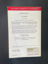 Load image into Gallery viewer, Ulysses by James Joyce: photo of the bak cover which shows minor creasing and scuff marks along the edges, and a large crease running down the length of the cover.
