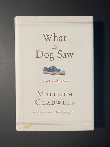 What the Dog Saw and Other Adventures by Malcolm Gladwell: photo of the front cover which shows a small patch of discolouring on the bottom left-hand side.
