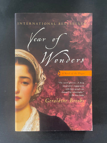 Book cover of 'Year of Wonders' by Geraldine Brooks on a dark background. There is creasing on the bottom-right corner.
