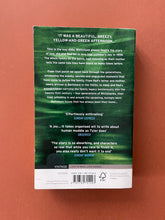 Load image into Gallery viewer, A Spool of Blue Thread by Anne Tyler: photo of the back cover which shows very minor scuff marks along the edges, and a small square-shaped patch of laminating that has come off (under the last review), possibly when a price tag was ripped off.
