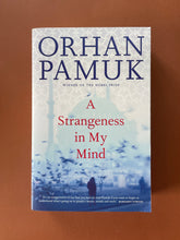 Load image into Gallery viewer, A Strangeness in My Mind by Orhan Pamuk: photo of the front cover which shows minor scuff marks on the bottom-right corner.
