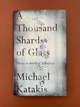 Load image into Gallery viewer, A Thousand Shards of Glass by Michael Katakis: photo of front cover which shows minor scuff marks along the edges.
