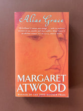 Load image into Gallery viewer, Alias Grace by Margaret Atwood: photo of the front cover which shows very minor scuff marks along the edges, and obvious creasing on the bottom-right corner.

