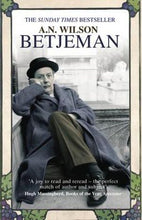 Load image into Gallery viewer, Betjeman by A. N. Wilson: stock image of front cover; a photograph of a man wearing a long grey overcoat, brown pants, black leather shoes and a black bowler hat. He is sitting on the ground, on the rooftop of a building, leaning against a low concrete wall. His right elbow sits on the top of the wall, his head is resting in his right hand. His right leg is tucked underneath himself, his left leg bent upwards at the knee. There are out-of-focus white buildings in the background. THE SUNDAY TIMES BESTSELLER
