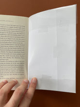 Load image into Gallery viewer, Boy Erased by Garrard Conley: photo of the inside of the back cover which shows a plastic covering that a previous owner has covered the book with.
