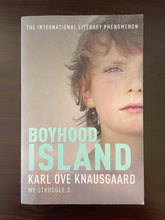 Load image into Gallery viewer, Boyhood Island by Karl Ove Knausgaard book: photo of the front cover. There are very minor scuff marks visible on the top-right and bottom-right corners, and along the bottom edge of the cover.
