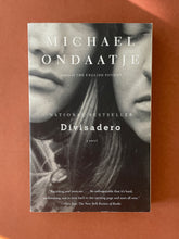 Load image into Gallery viewer, Divisadero by Michael Ondaatje: photo of the front cover which shows very minor scuff marks along the edges.
