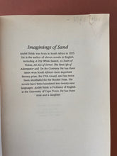 Load image into Gallery viewer, Imaginings of Sand by Andre Brink: photo of the first page in the book which is ripped at the top-right corner, and which also has written in pencil the name &quot;Kylie Race&quot;. No other tearing or writing in pen or pencil anywhere in the book.

