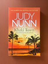 Load image into Gallery viewer, Khaki Towns by Judy Nunn: photo of the front cover which shows creasing on the bottom-half of the cover.
