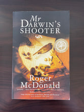 Load image into Gallery viewer, Mr Darwin&#39;s Shooter by Roger McDonald book: photo of front cover, which shows minor scuff marks along the edges, and some vertical creasing at the bottom of the cover, running parallel to the spine.
