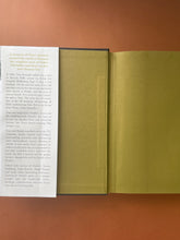 Load image into Gallery viewer, Searching for Schindler by Tom Keneally: photo of the inside of front cover and the first page, which shows a crease running down the flap of the dust jacket, and a faint vertical bend/crease running down the length of the first page. No other creased pages in the book.
