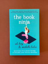 Load image into Gallery viewer, The Book Ninja by Ali Berg &amp; Michelle Kalus: photo of the front cover which shows very minor (barely visible) scuff marks along the edges.
