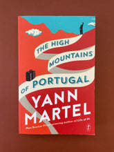 Load image into Gallery viewer, The High Mountains of Portugal by Yann Martel : photo of the front cover which shows obvious creasing running parallel to the spine, and very minor scuff marks along the edges.
