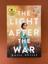 Load image into Gallery viewer, The Light After the War by Anita Abriel: photo of the front cover which shows very minor scuff marks along the edges.
