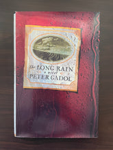 Load image into Gallery viewer, The Long Rain by Peter Gadol book: photo of front cover. There are minor scuff marks visible around the edges of the dust jacket which cause the edges to curve upwards slightly.
