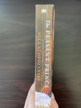 Load image into Gallery viewer, The Peasant Prince by Alex Storozynski book: photo of obvious creasing along the spine.
