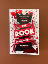 Load image into Gallery viewer, The Rook by Daniel O&#39;Malley: photo of the front cover which shows a very minor scuff mark on the bottom-right corner which has caused the corner to curl upwards very slightly.
