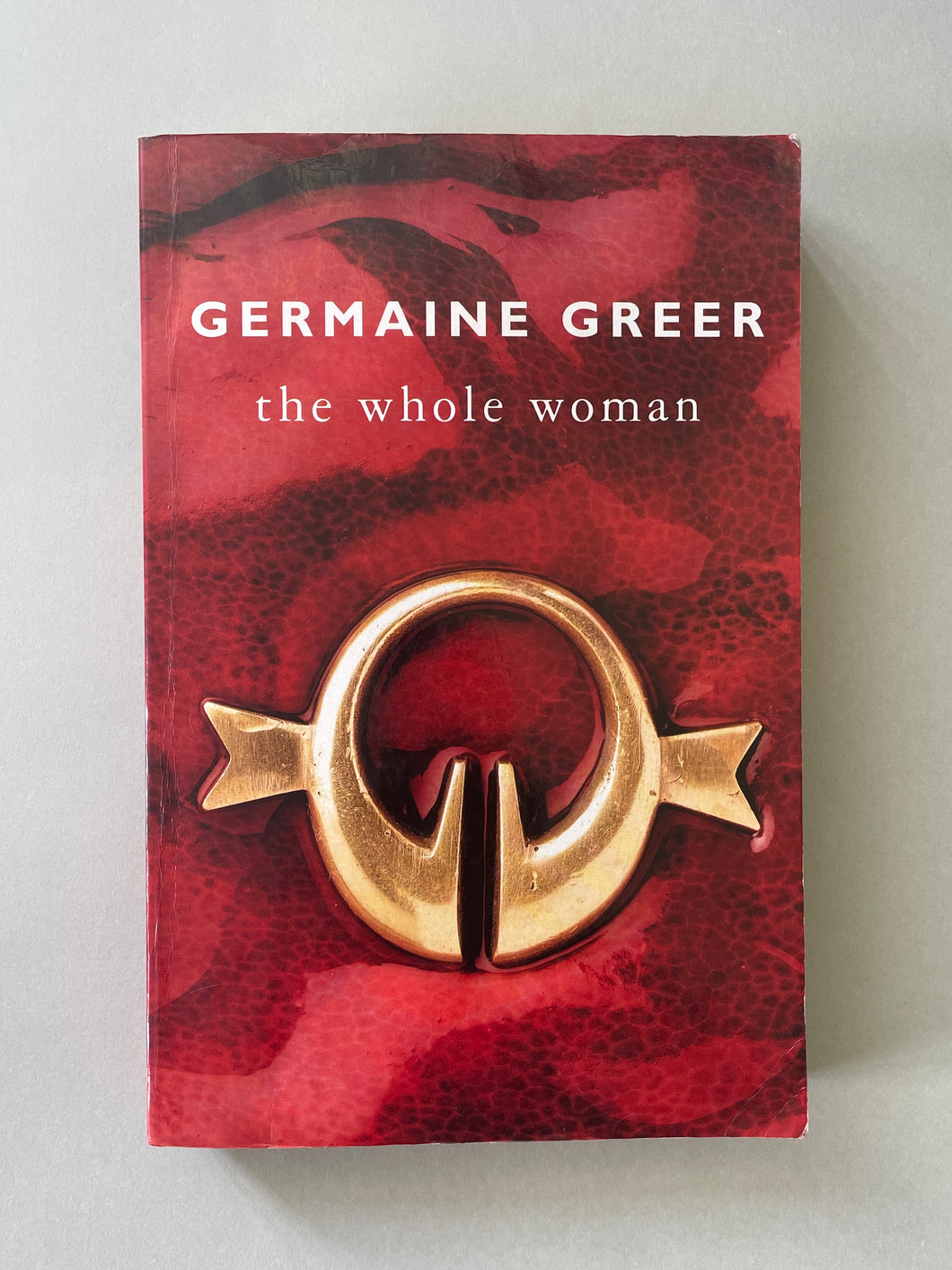 The Whole Woman by Germaine Greer: photo of the front cover which shows scuff marks, creasing and scratches.