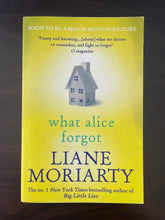 Load image into Gallery viewer, What Alice Forgot by Liane Moriarty book: photo of front cover. There are very minor scuff marks on the top and bottom corners which also curve upwards very slightly.
