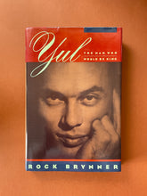 Load image into Gallery viewer, Yul-The Man Who Would Be King by Rock Brynner: photo of the front cover which shows minor scuff marks and creasing along the edges of the dust jacket.
